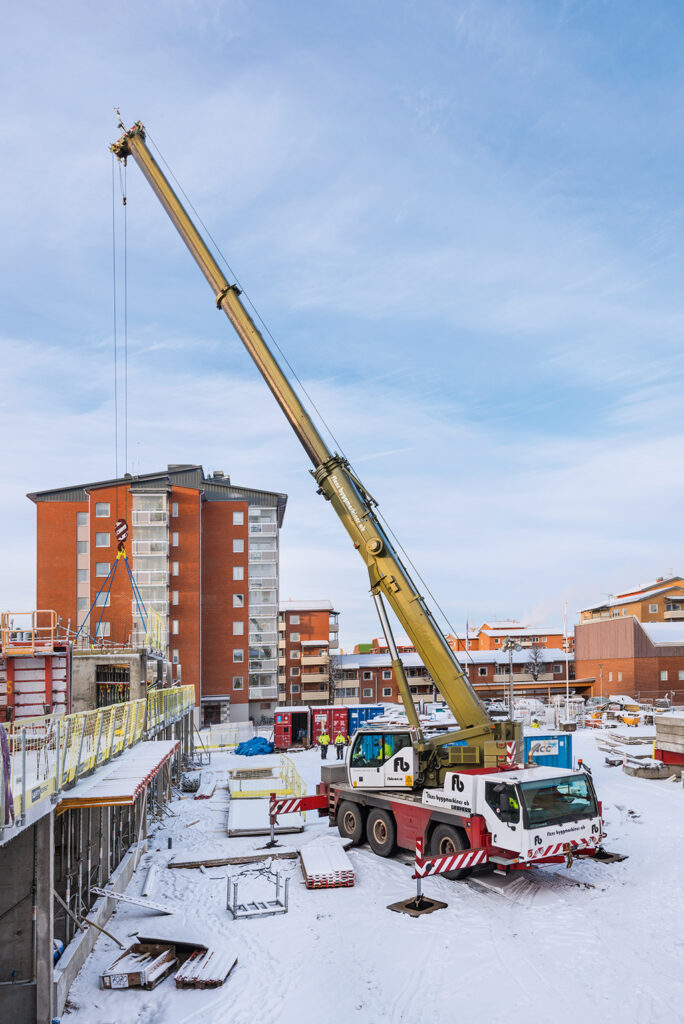 Byggkran på arbetsplatsen med blå himmel i bakgrunden